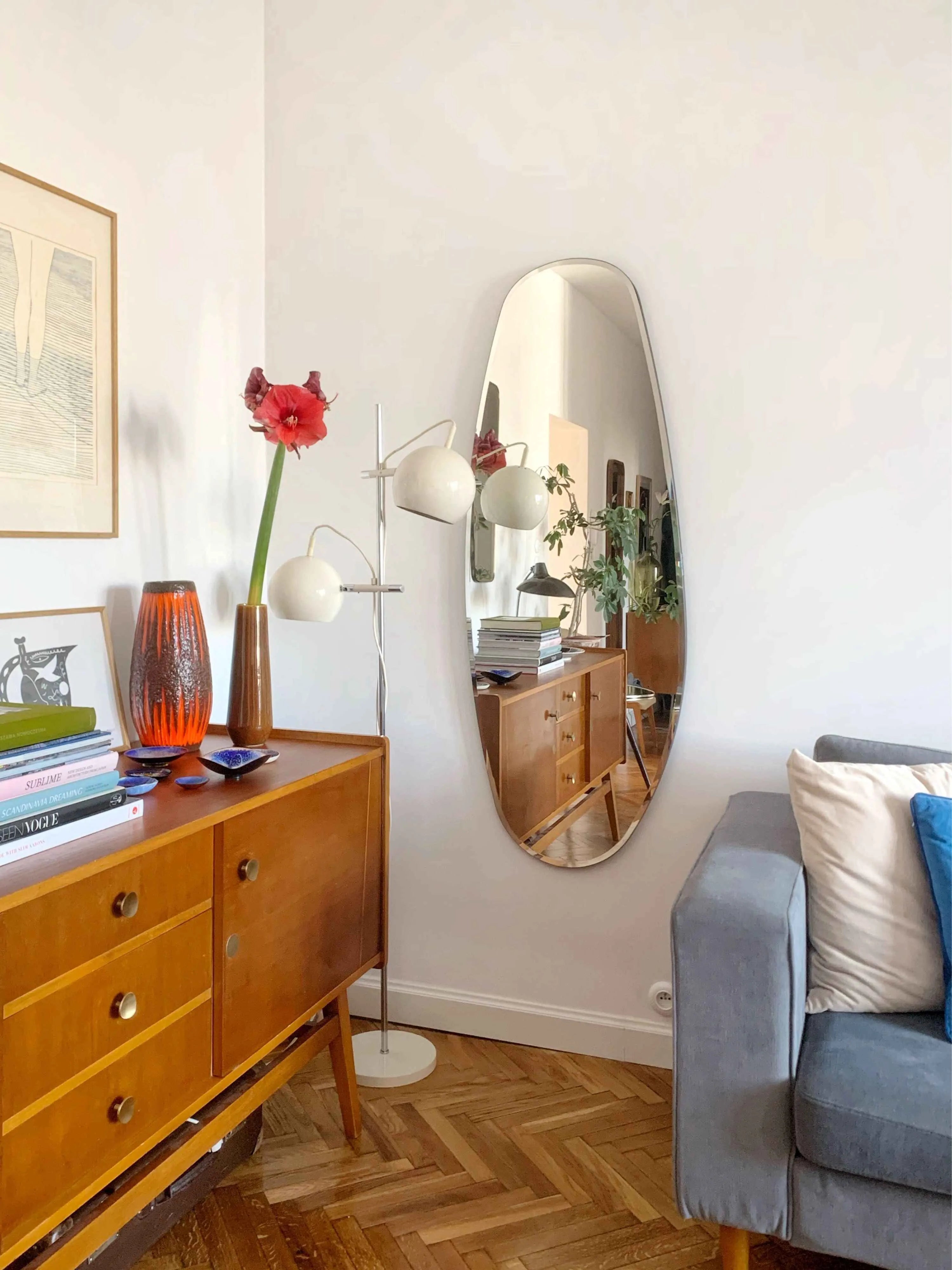Opal Mirror Large in living room reflecting a book case and some plants