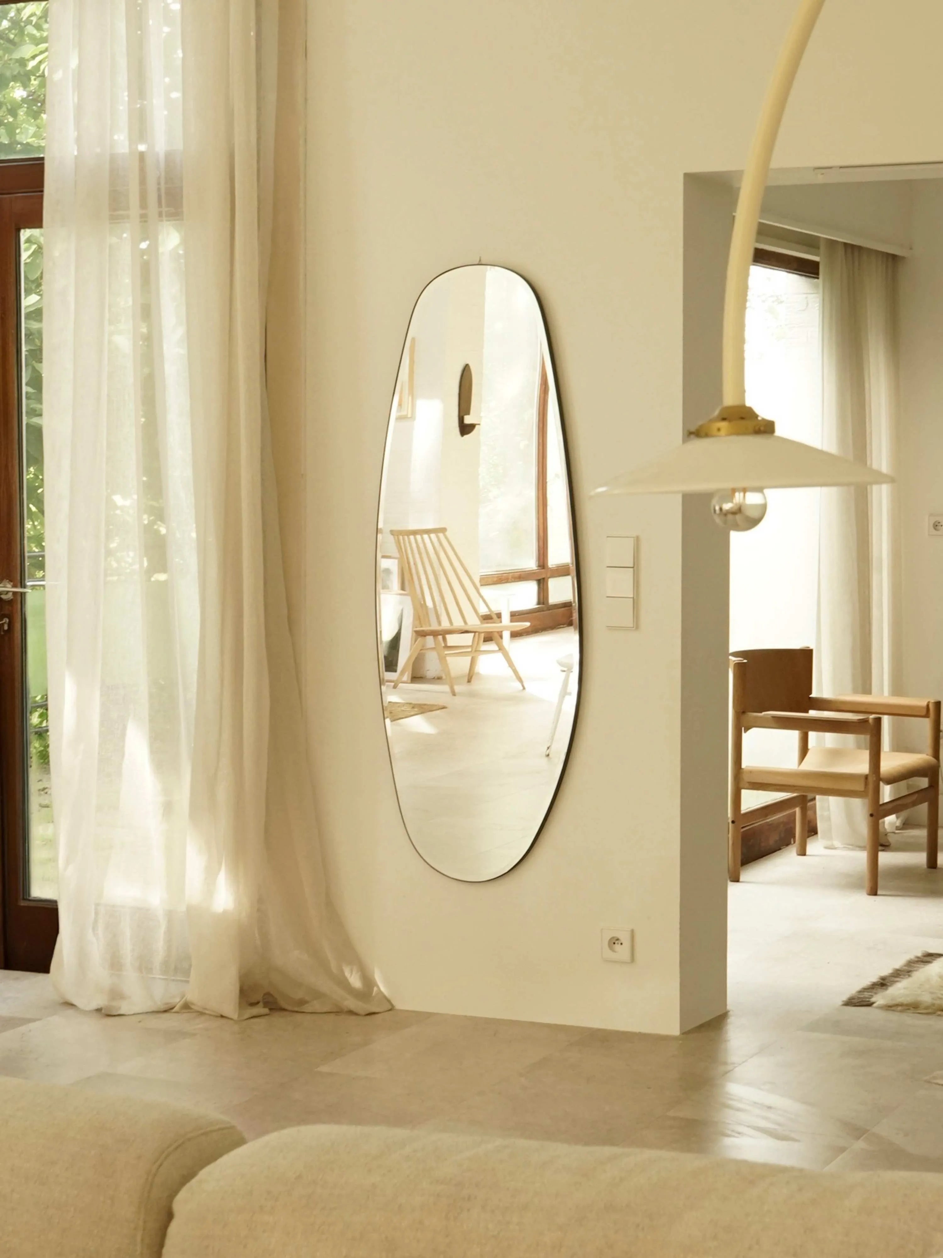 Asymmetrical Opal Mirror Large styled in a minimalistic hallway with natural light.